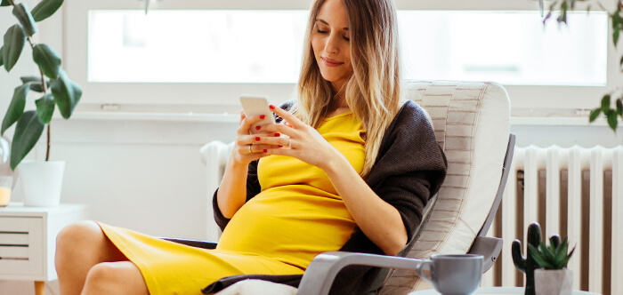 Foto von Schwangere Frau mit Smartphone in der Hand